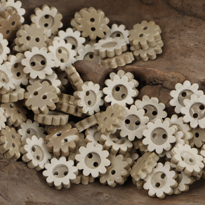 Sunflower-shaped coconut shell buttons, two holes, pale tan with scalloped edges