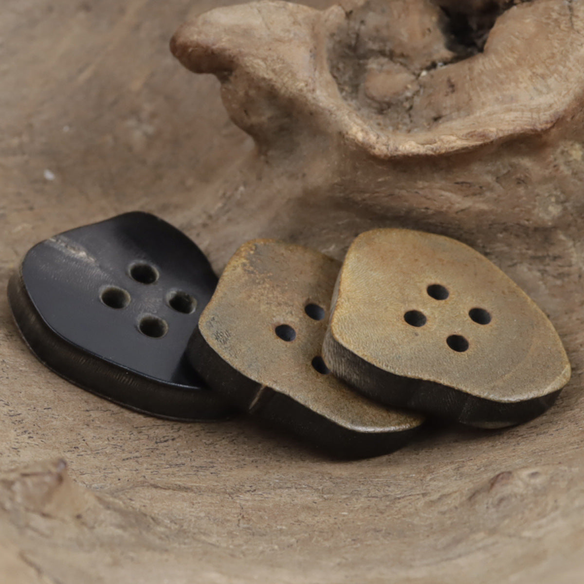 Natural horn buttons, mixed dark and tan irregular shapes, each with 4 holes.