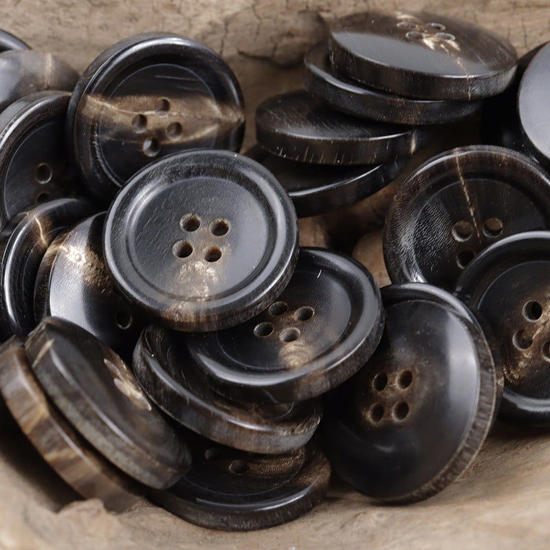 Black real horn buttons pile, dark round faces with varied hole layouts