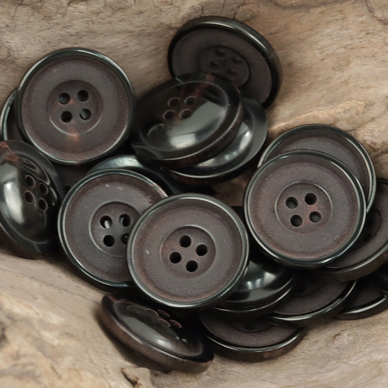 Mixed view of 25mm round dark horn buttons, four-hole fronts