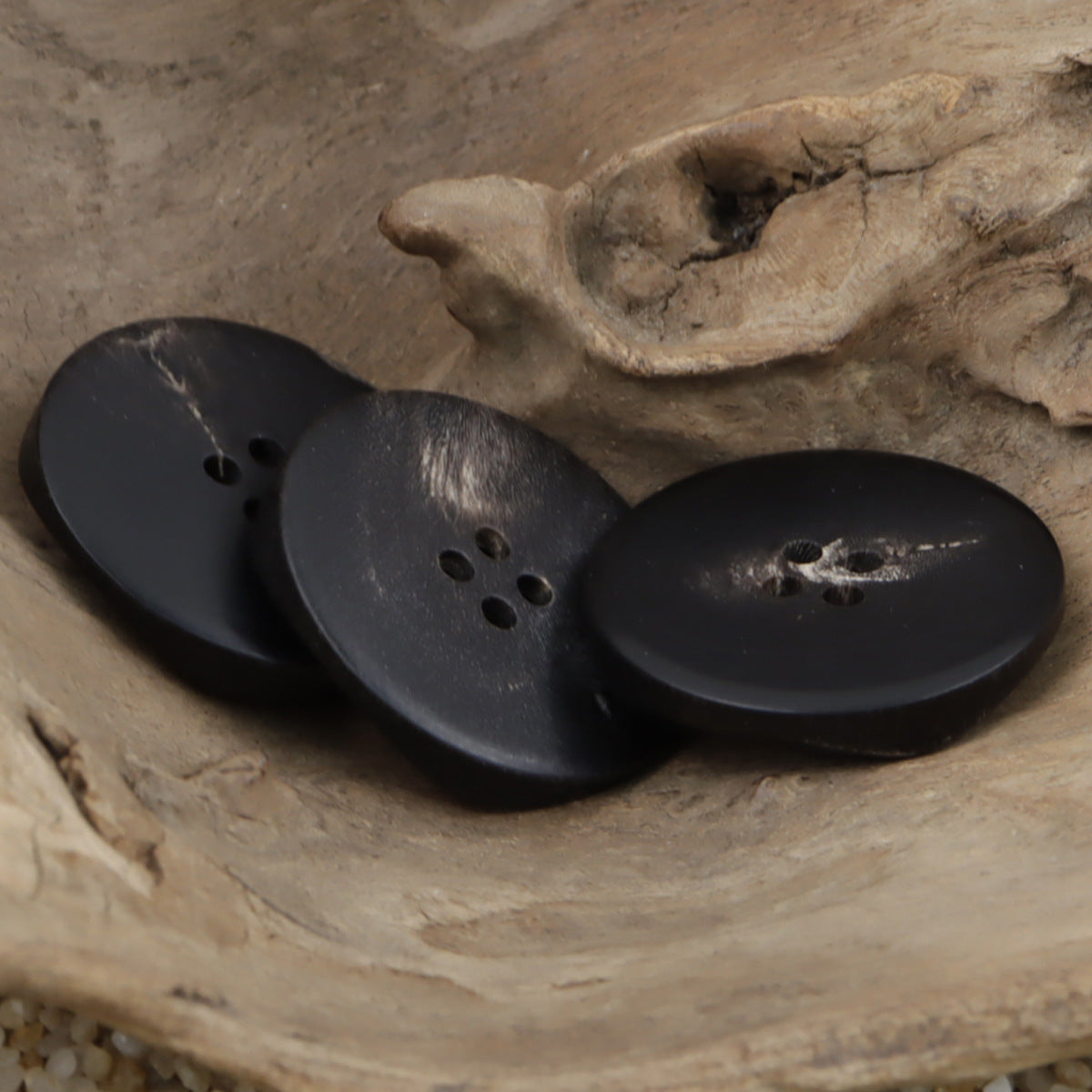 3 large irregular black buffalo horn buttons with 4-hole openings