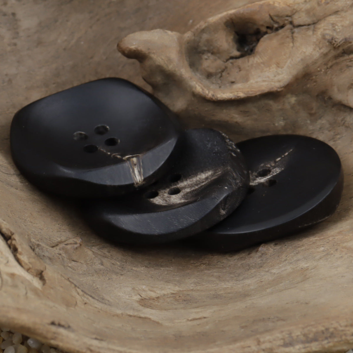 Large black buffalo horn buttons, irregular shape, 4-hole fronts (close-up)