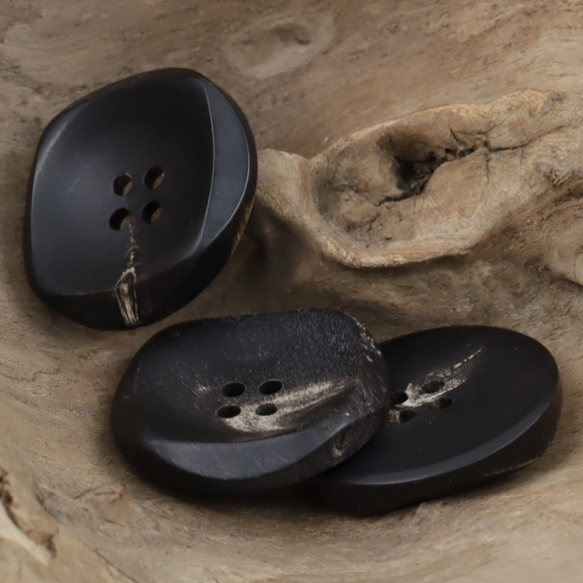 Set of 2 large irregular black horn buttons with 4-hole fronts