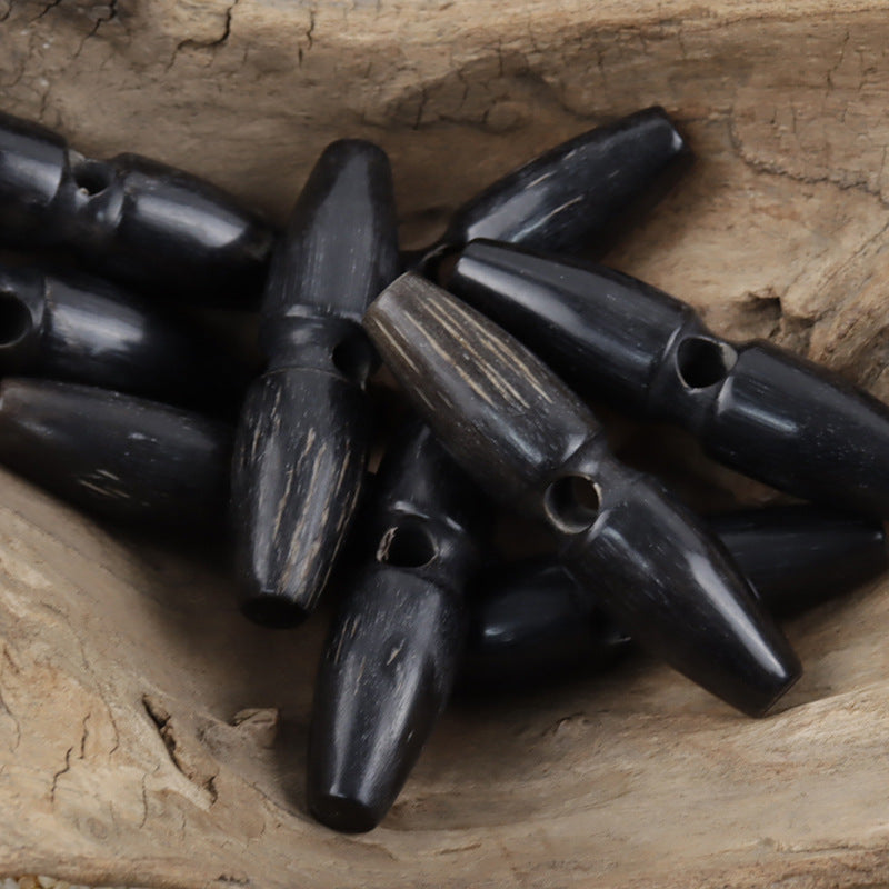 Einloch-Hornknöpfe (schwarz), 60mm, mehrere Stück auf Holzunterlage