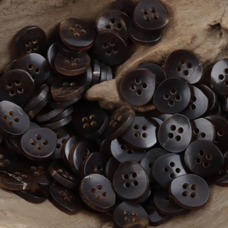 Brown 4-hole horn buttons, pear-shaped, angled close-up