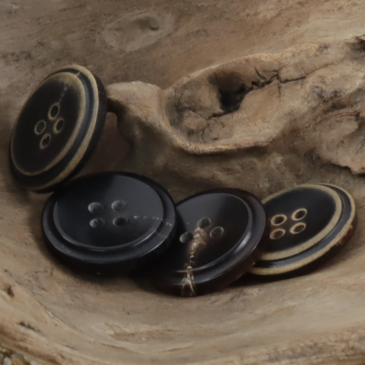 Mehrere Hornknöpfe mit 4-Loch-Design und verbranntem Außenrand, dunkel