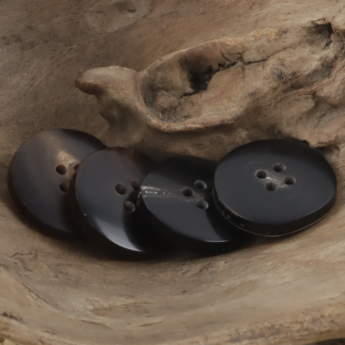 Hornknöpfe mit breitem, unregelmäßigem Rand, 4 Löcher, Vorderansicht (braun/dunkel)
