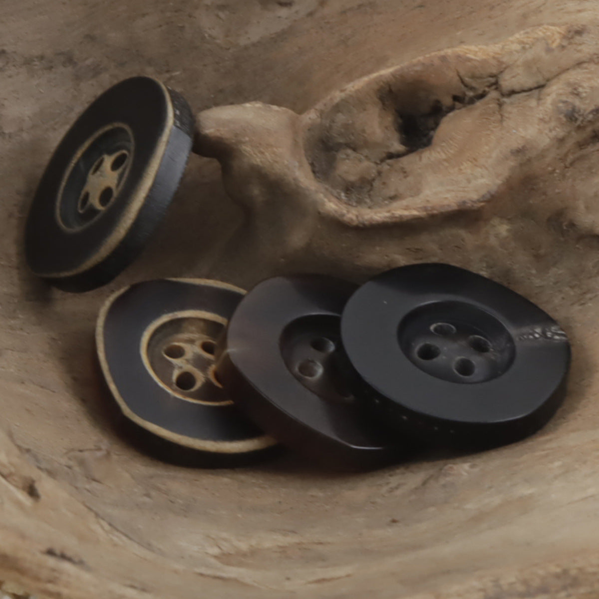 Hornknöpfe mit unregelmäßig breitem Rand, 4 Löcher, Vorderansicht (dunkel)