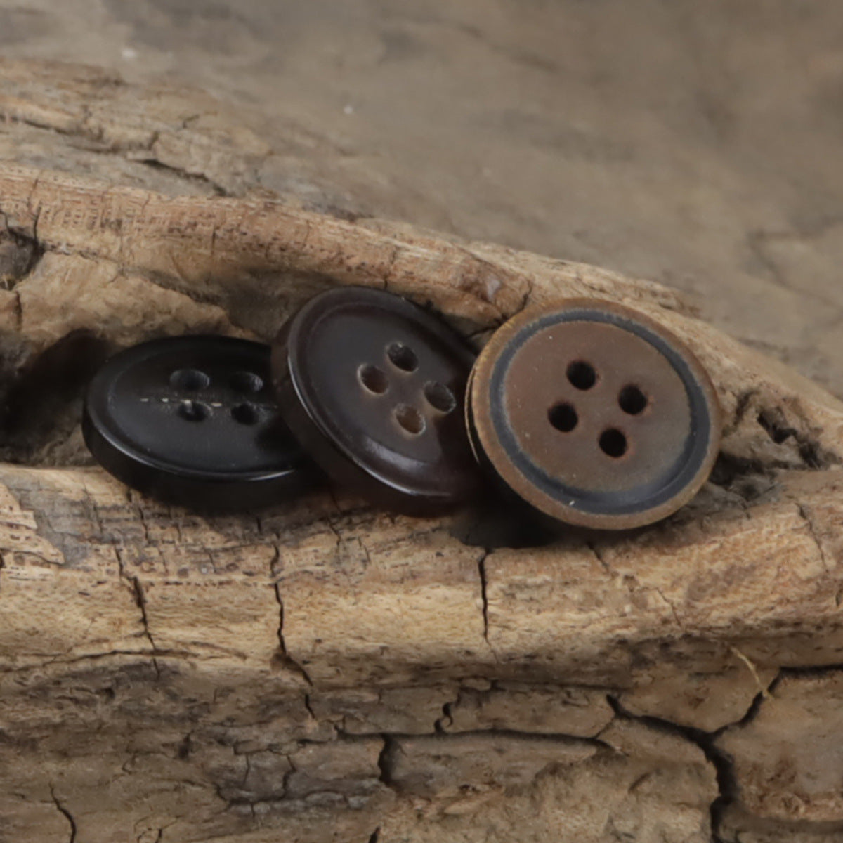 Vintage charred horn buttons, 4-hole style, mixed dark and brown on wood (10 pcs)