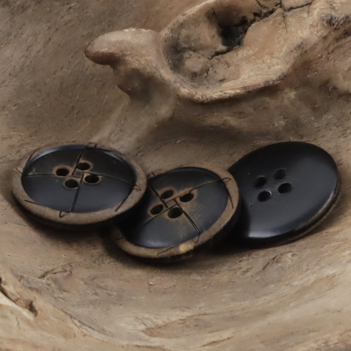 Black round cow horn buttons, each with 4 holes and a horn-colored rim.