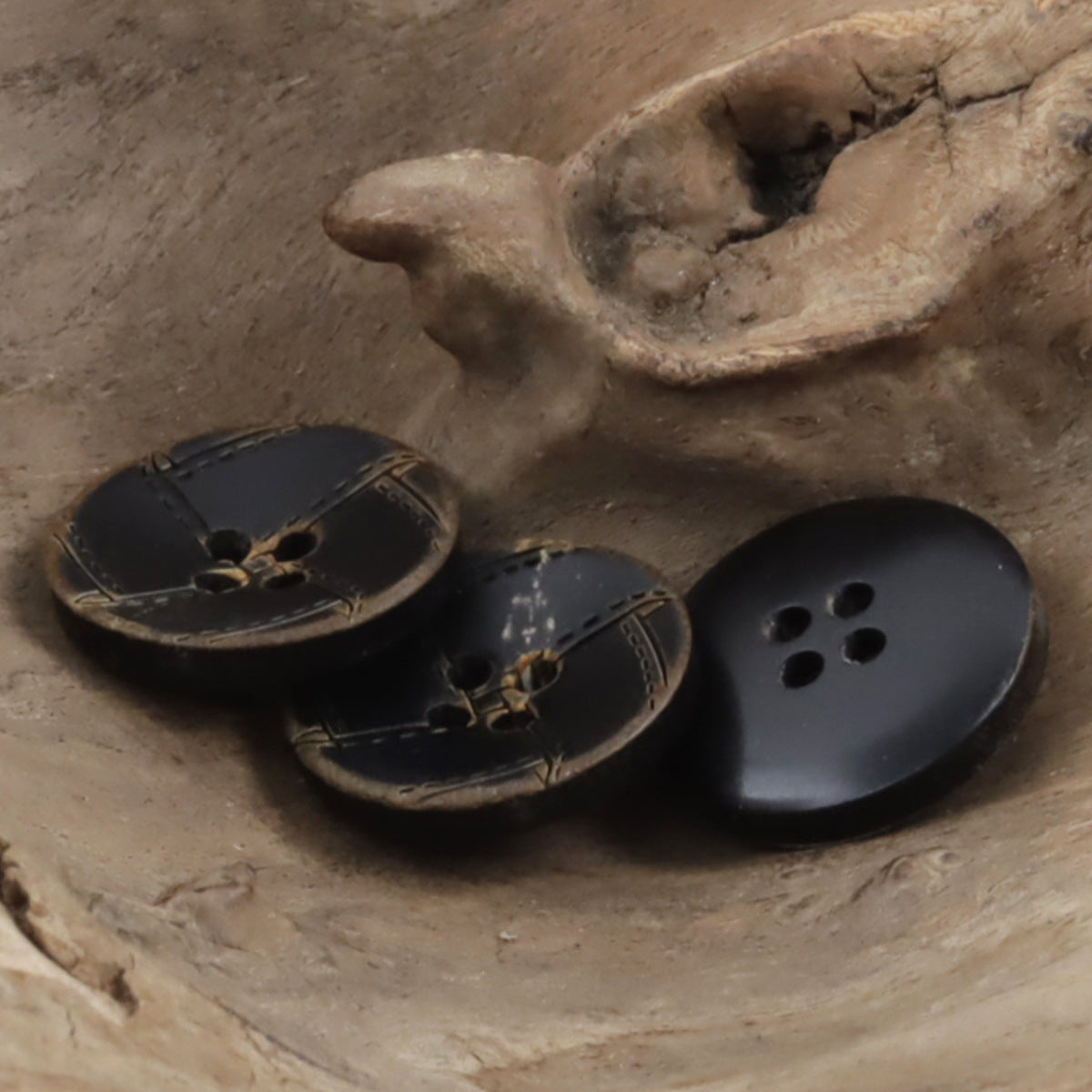 Set of dark horn jacket buttons with tan stitched pattern and 4-hole fronts