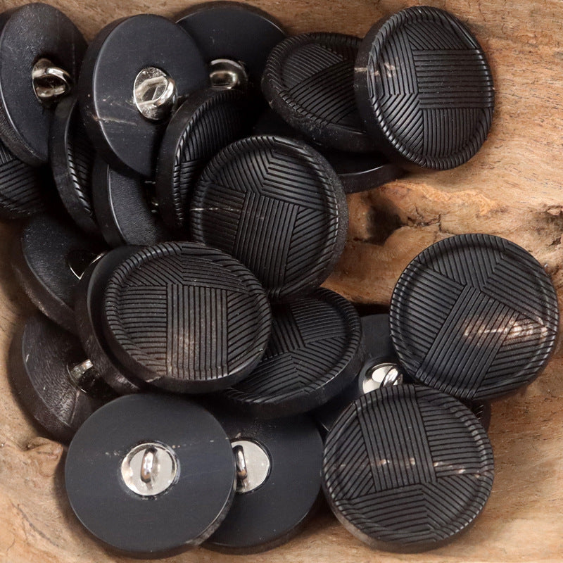 Assorted black round buttons with metal shanks and embossed geometric stripe fronts