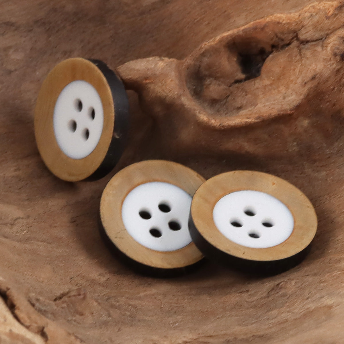 Cow horn buttons with tan rim and white fronts, four-hole button faces