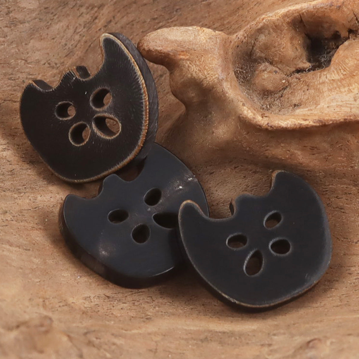 4-hole cow horn style buttons in dark finish, apple charm shape