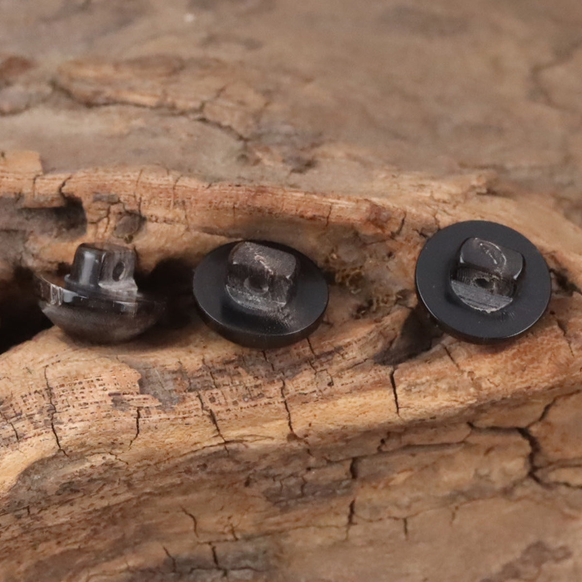 Pair of black mushroom-head horn buttons, one top view and one with shank
