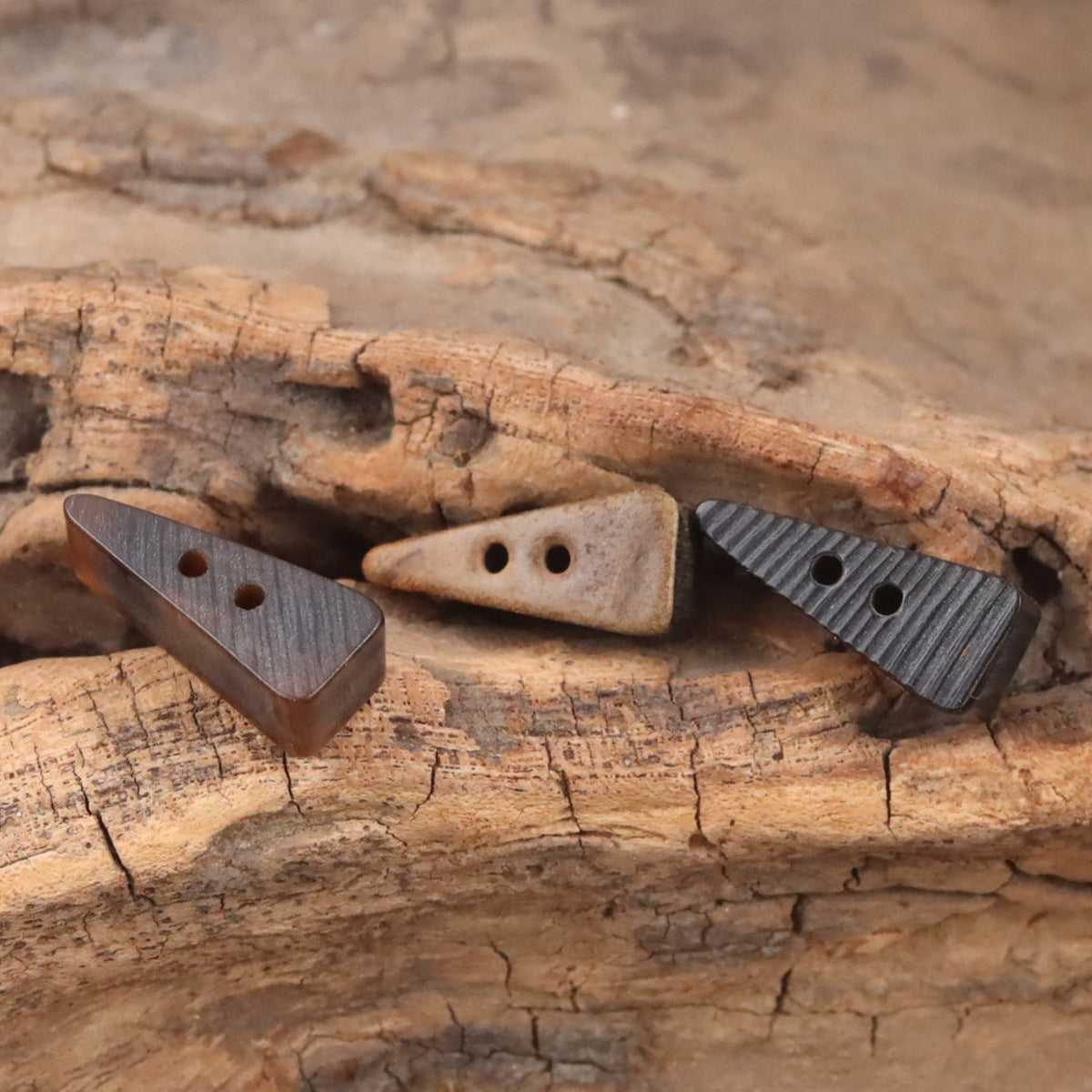 Triangular ox horn buttons, cream and dark striped look, each with two holes
