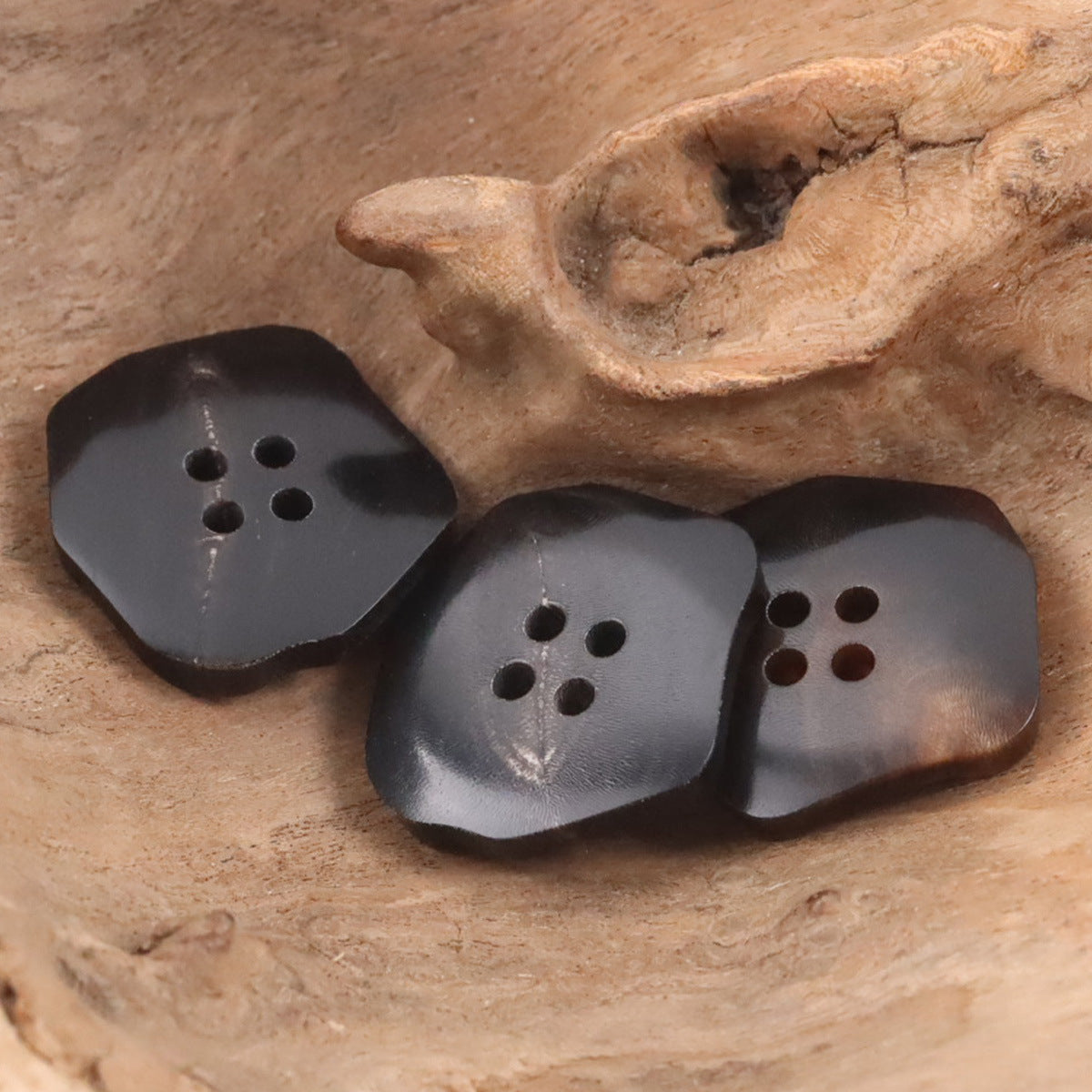 Lotsofbuttons black exotic-shaped ox horn buttons with four-hole cutouts