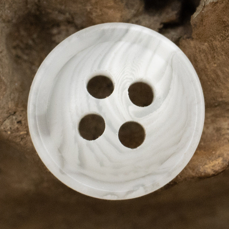 White resin shirt button with four holes, smooth thin edge
