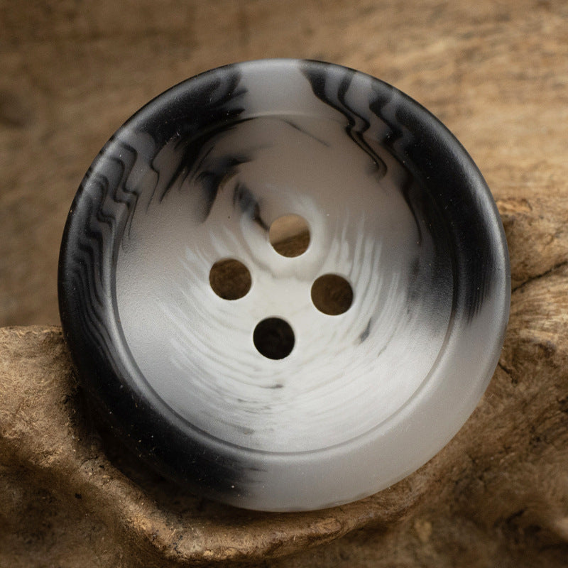 Dark gray resin coat button, bowl-shaped front with four holes and marbled finish