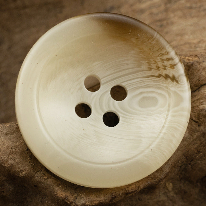 Cream resin coat button, bowl-shaped, four-hole front with subtle swirl pattern