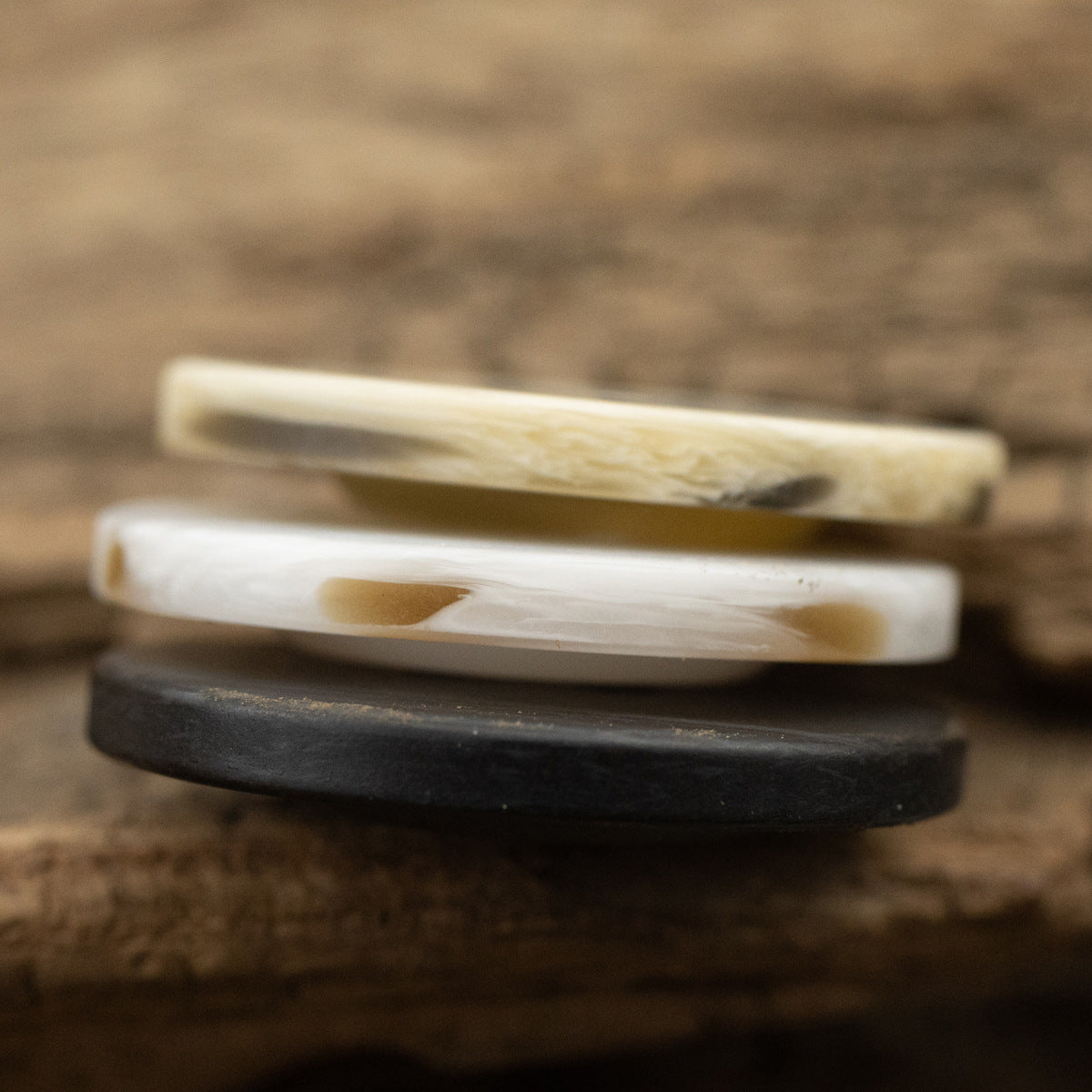 Stacked flat resin buttons, off-white and black, two-hole side detail