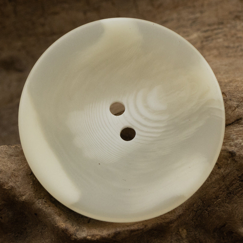 Off-white/cream two-hole bowl-shaped resin coat button