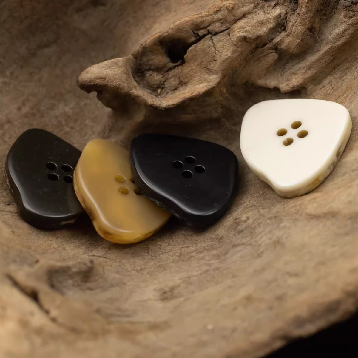 Cluster of large irregular resin buttons: dark brown, amber, black, and white marble-look.