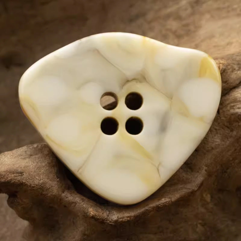 Large irregular resin button, cream/white marble-look with 4 holes.