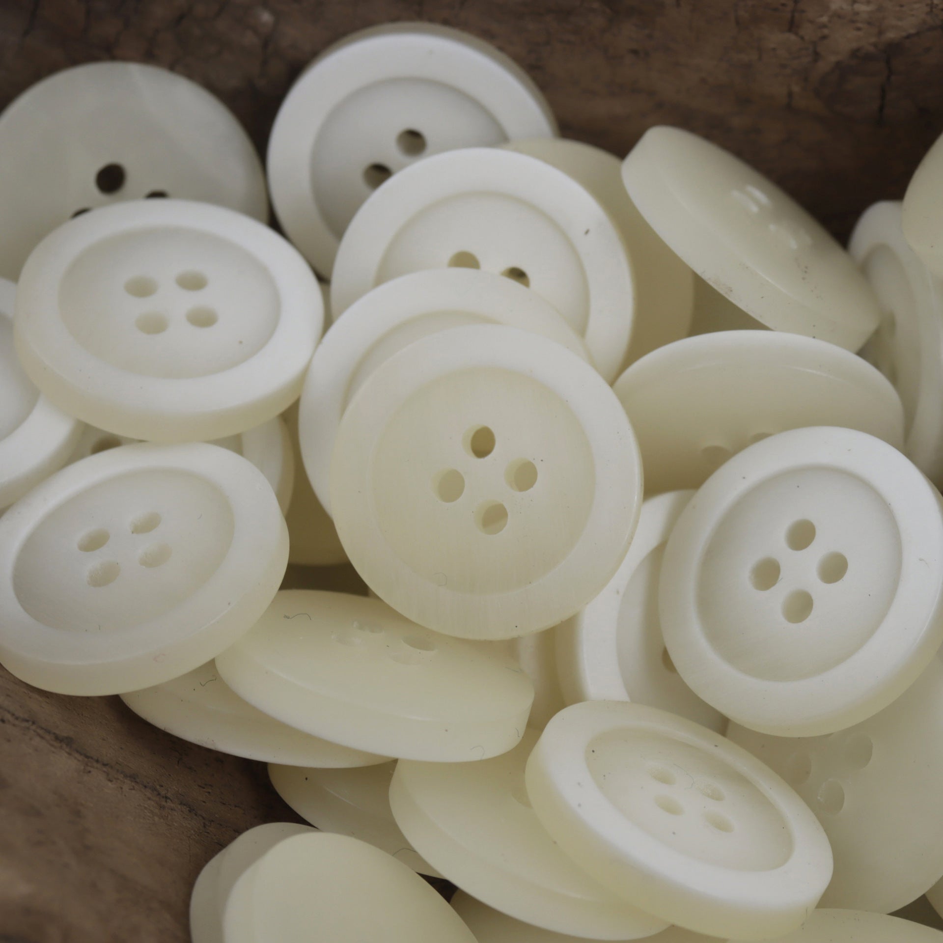 Cluster of round white resin buttons with 4 holes, smooth surface, 15–25mm