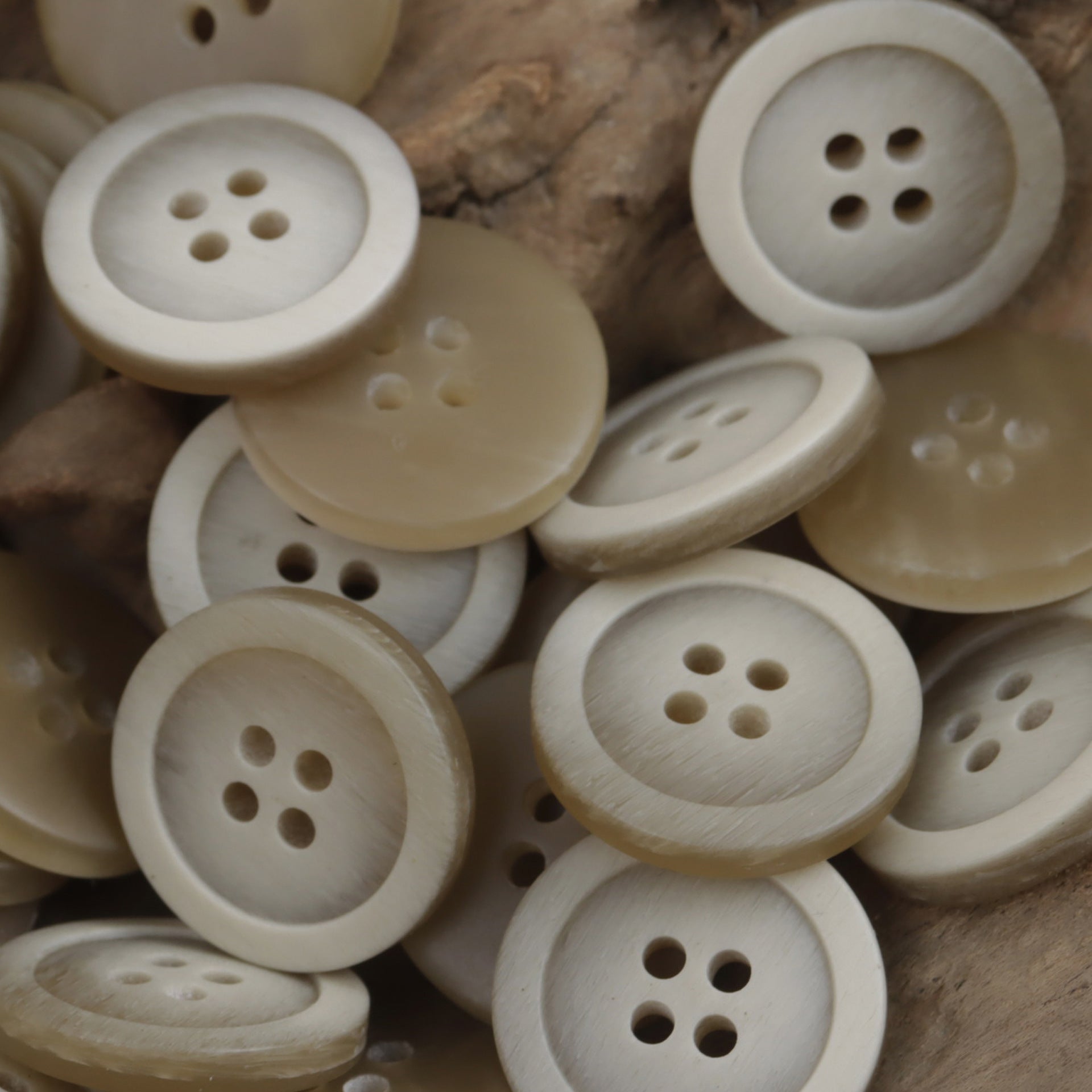 Mix of round resin buttons in cream and light beige, 4 holes, 15–25mm