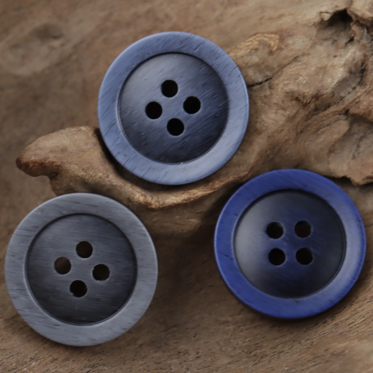 Assorted 4-hole resin buttons in gray-blue and dark blue wood-grain style