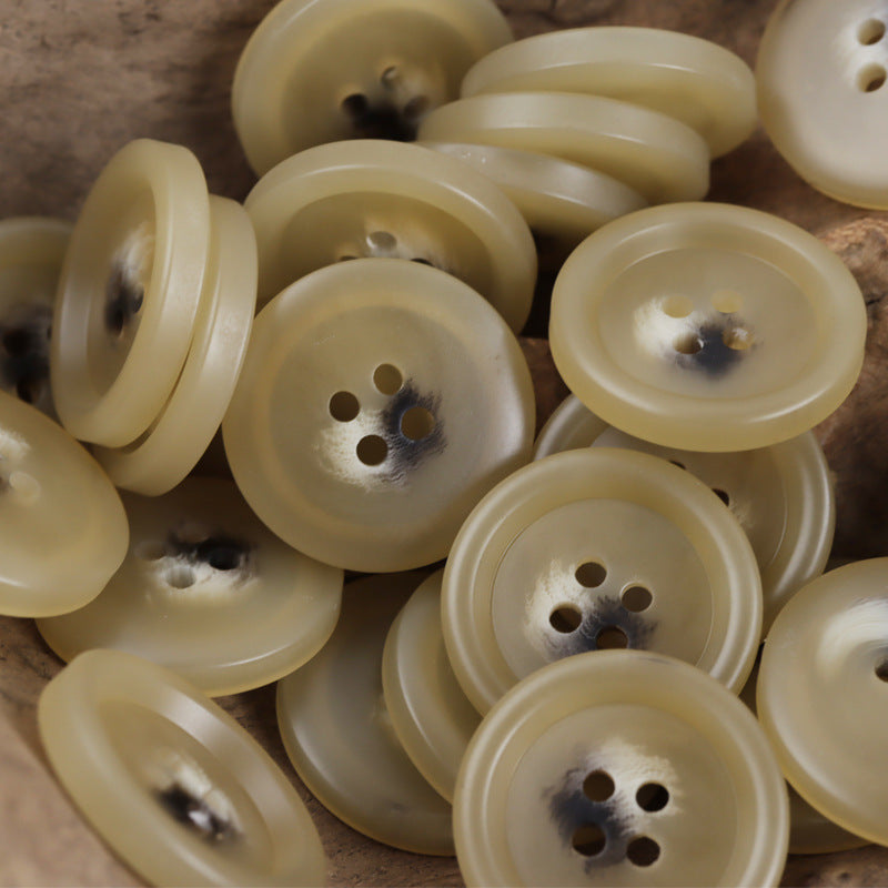 Light khaki resin 4-hole buttons, domed face close-up, assorted pieces