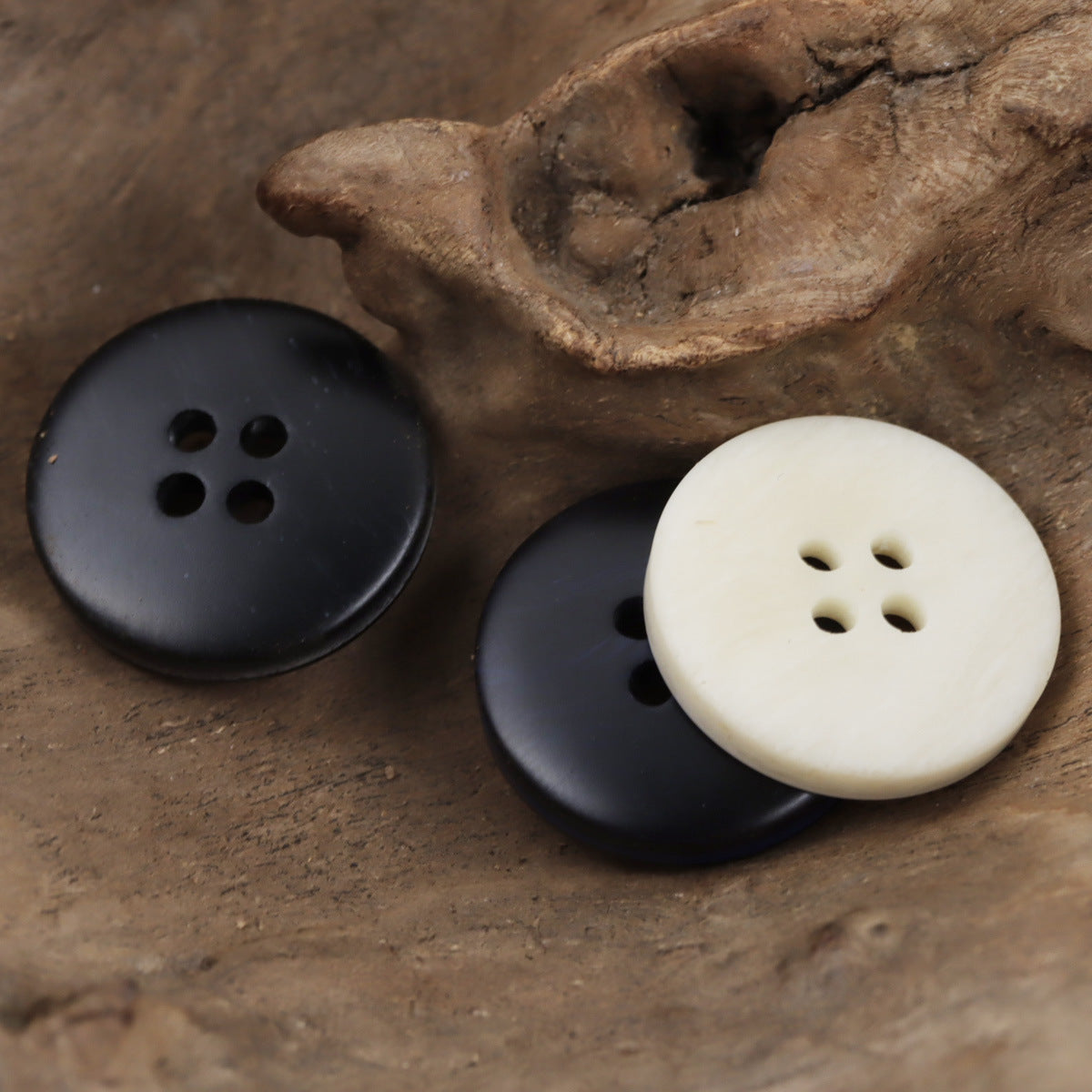 Resin buttons set in beige, gray, and blue; round, four-hole design with dark rim