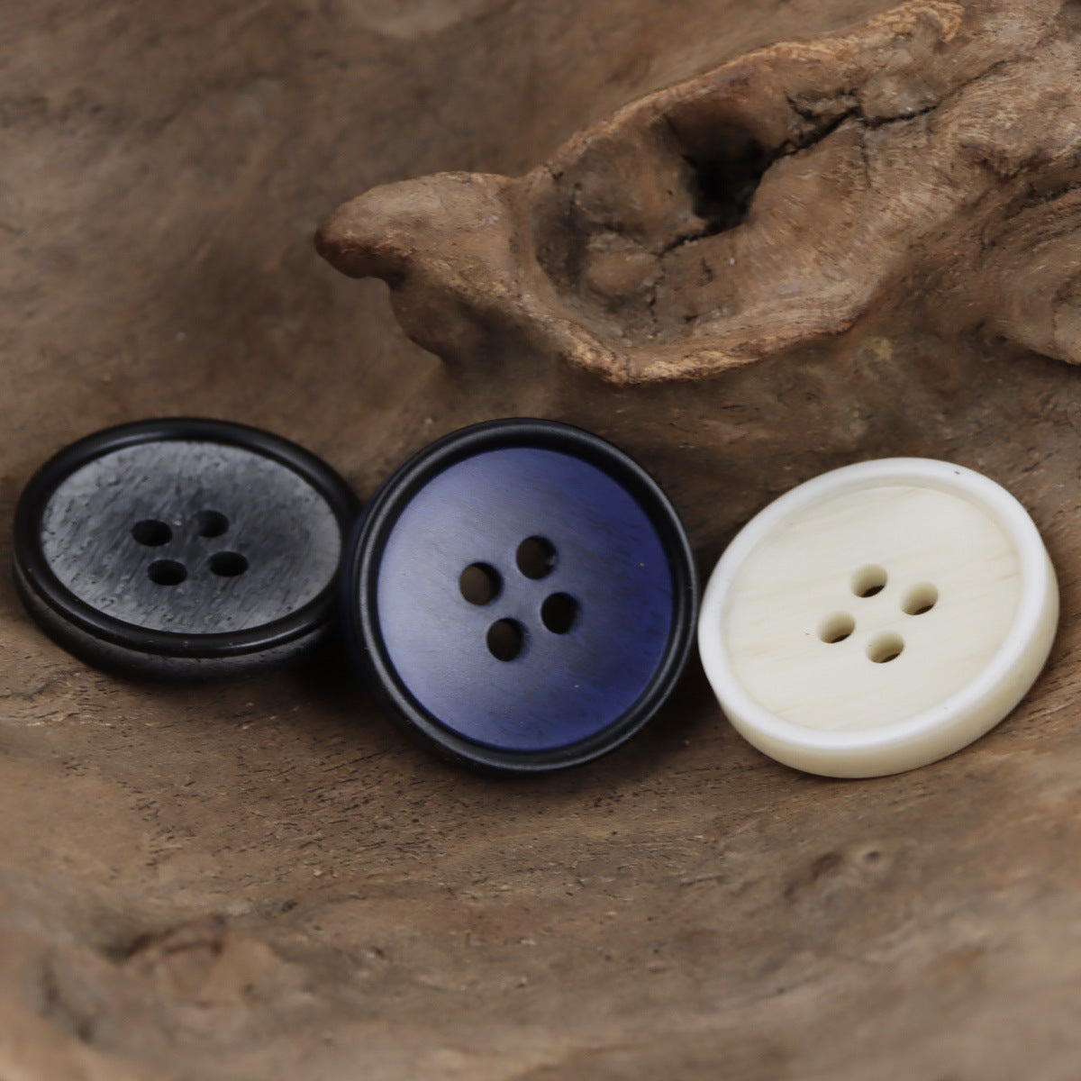 Round resin buttons in dark gray and cream/ivory with four-hole centers