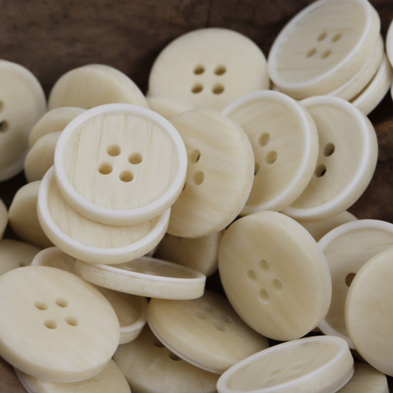Cream/ivory resin buttons, round with four-hole centers and subtle woodgrain finish