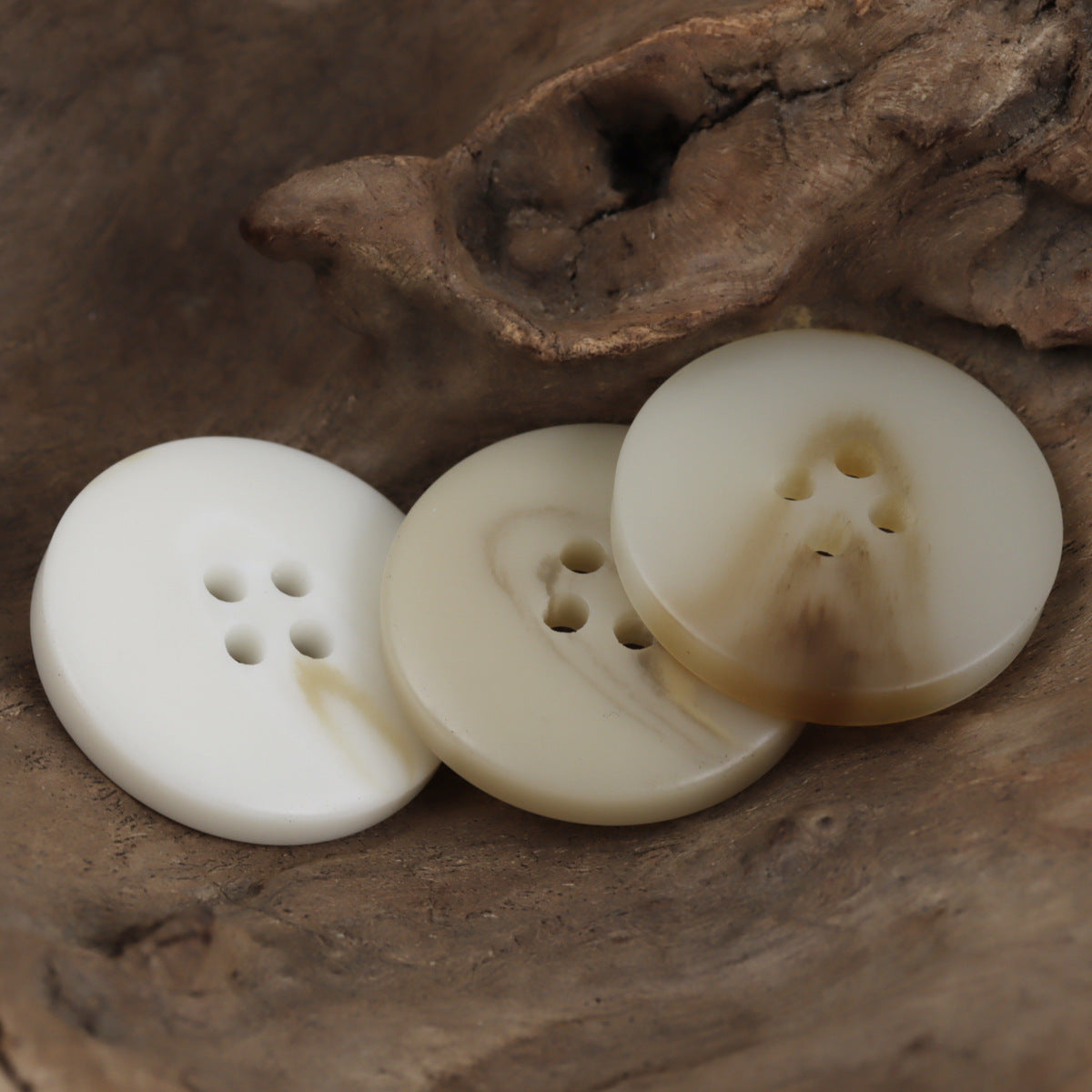 Beige Vierloch-Resin-Knöpfe, mehrere Knöpfe im Vorder- und Seitenblick