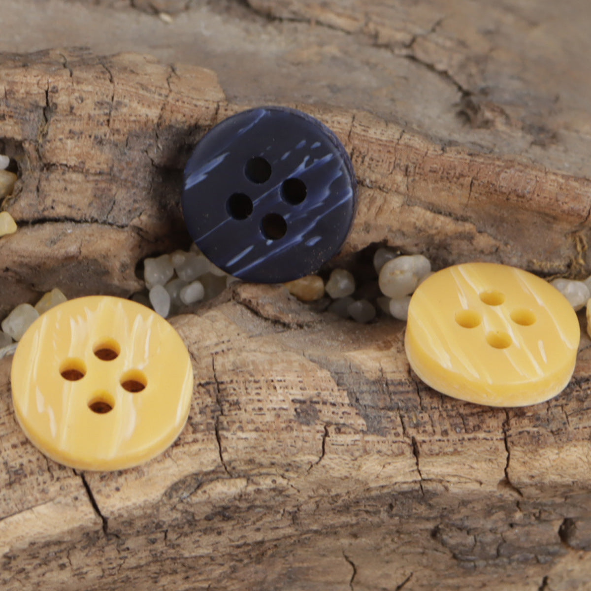 Round resin-look buttons: dark blue and yellow 4-hole fronts on wood