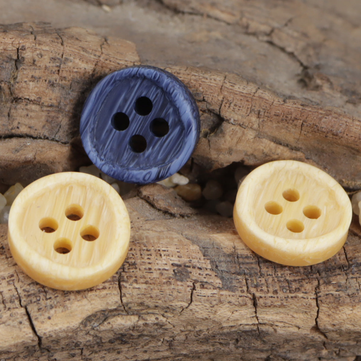 Set of round resin-look buttons with dark blue and light yellow 4-hole faces