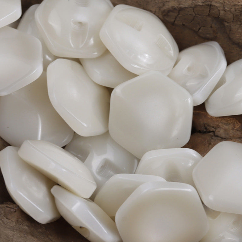 White hexagonal resin buttons, close-up showing raised 2-hole shank detail