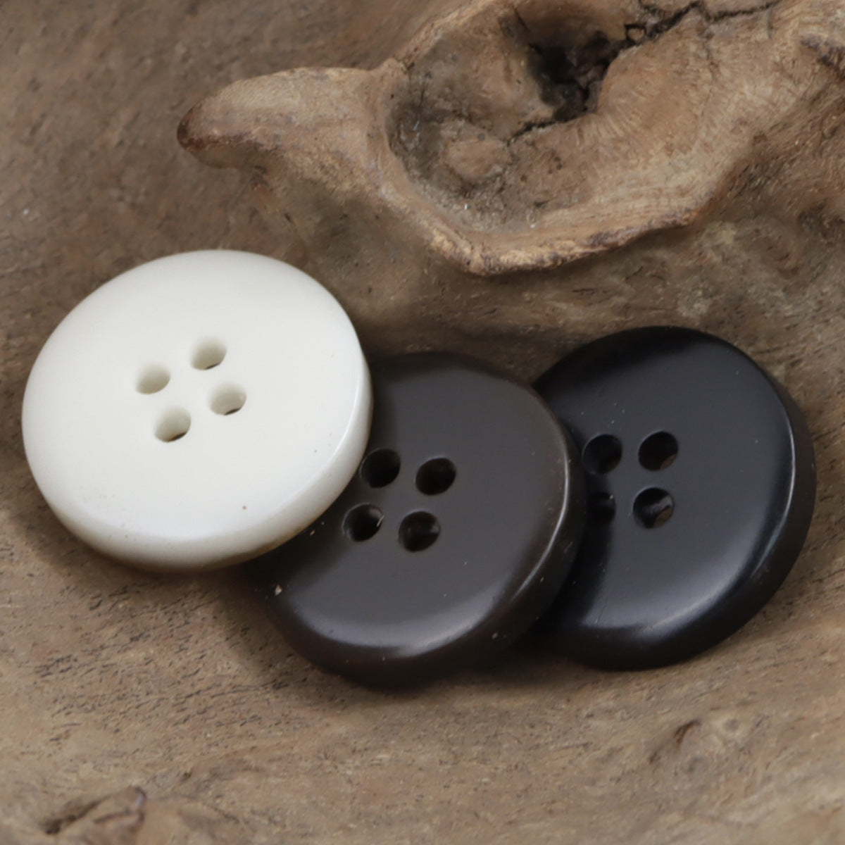 White and dark gray round four-hole resin buttons with shimmering finish
