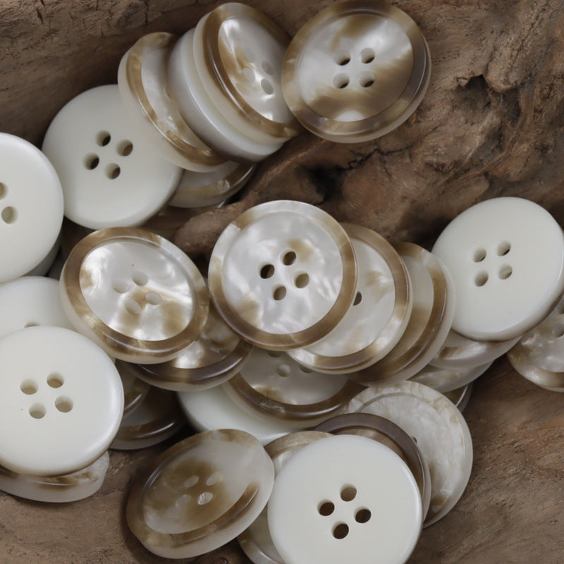 Round four-hole resin buttons in ivory and marbled cream with shimmering pattern