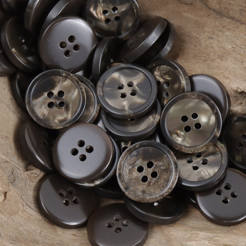 Assorted round four-hole resin buttons in dark gray, charcoal, and bronze shimmer
