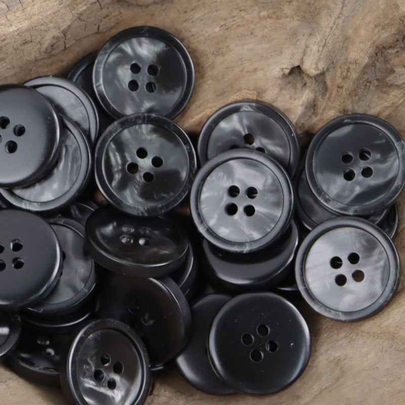 Assorted round four-hole resin buttons in black and metallic gray shimmer