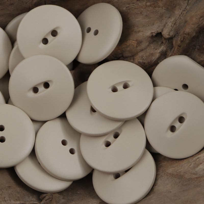 Cream 30mm matte fish-eye resin buttons with two-hole shanks, round flat fronts