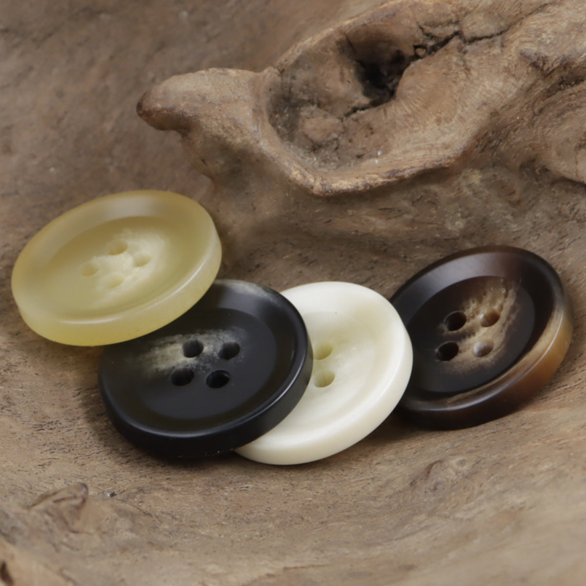 Assorted round 4-hole resin buttons in light beige, dark gray, black and brown tones