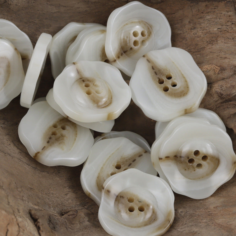 White irregular lotus resin buttons, four-hole design, stacked close-up