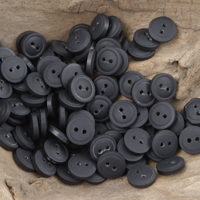 Pile of dark gray/black round resin buttons, 4-hole design (11.5mm)