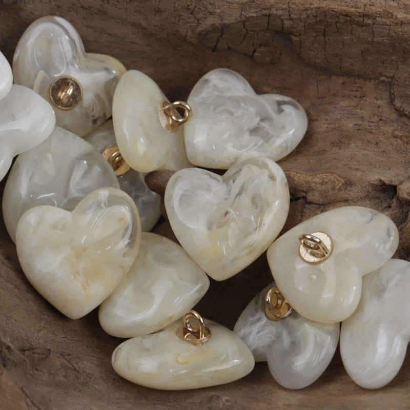 Heart-shaped resin buttons in beige/ivory with gold-tone metal shanks