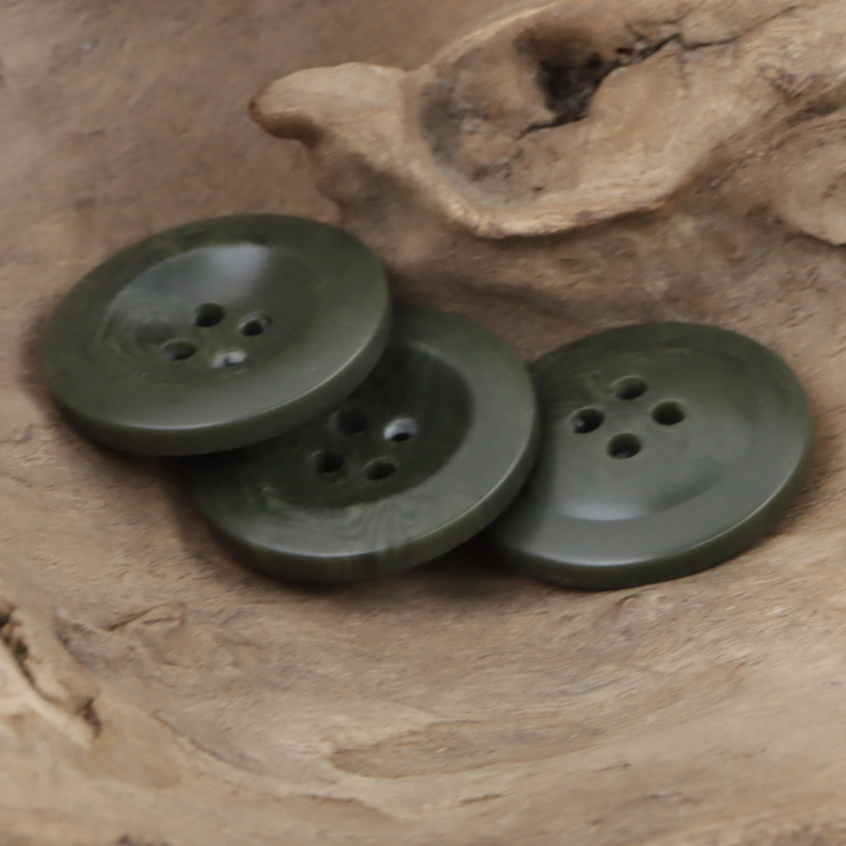 Three dark green wide-edge resin buttons with four holes each