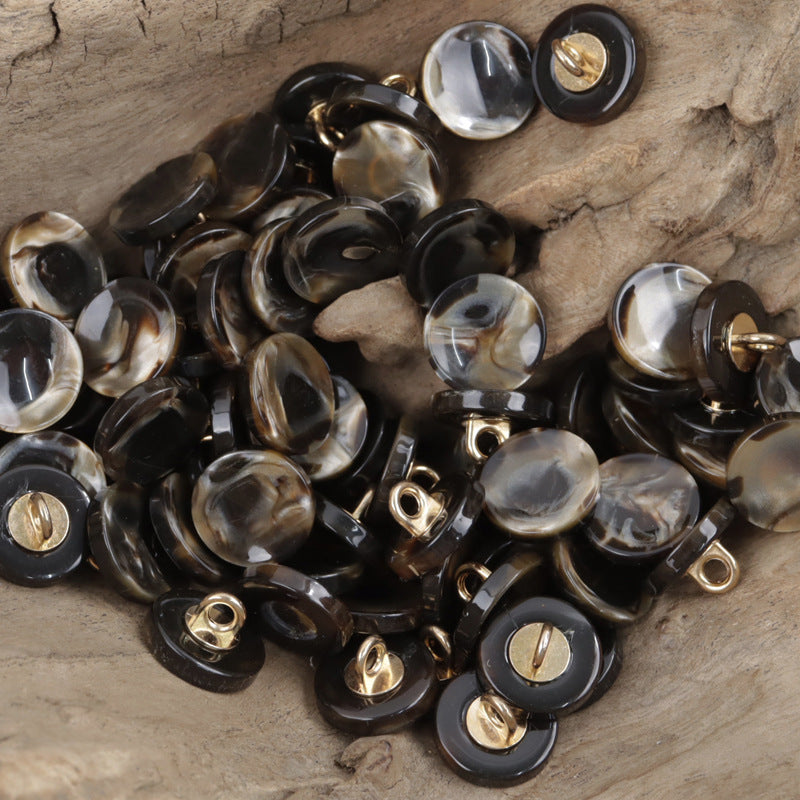 Black round resin buttons with gold metal shanks, glossy marbled finish